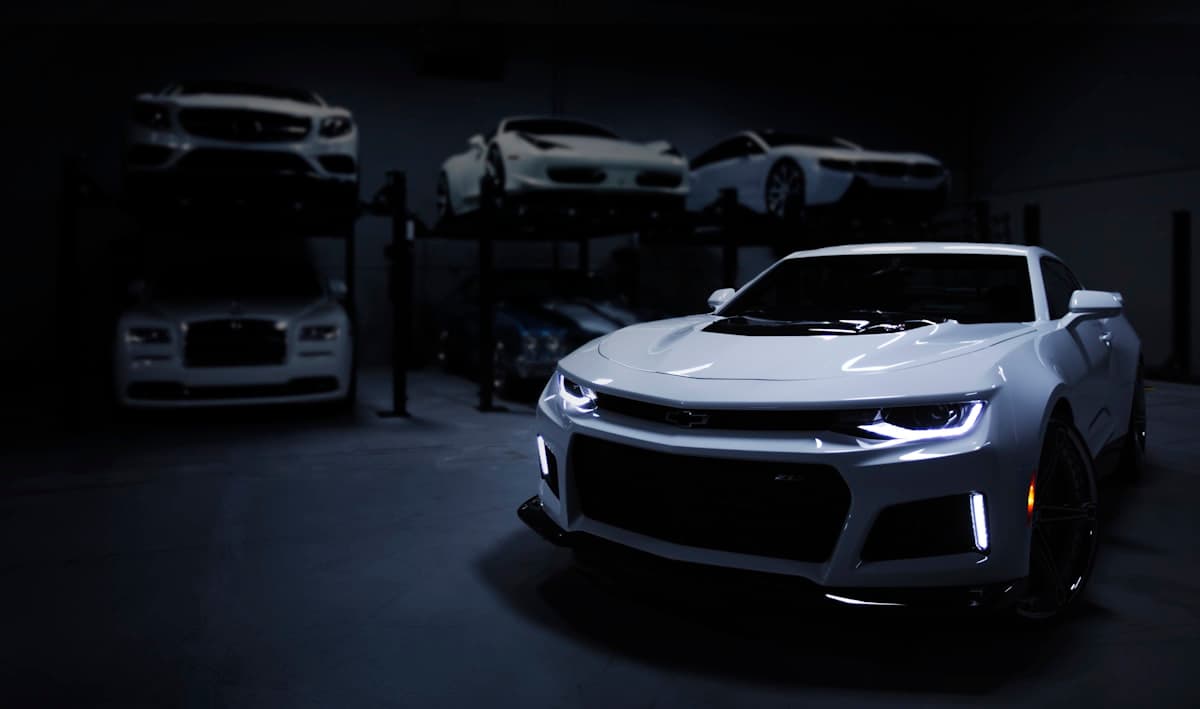 Voiture blanche détaillée dans un showroom sombre