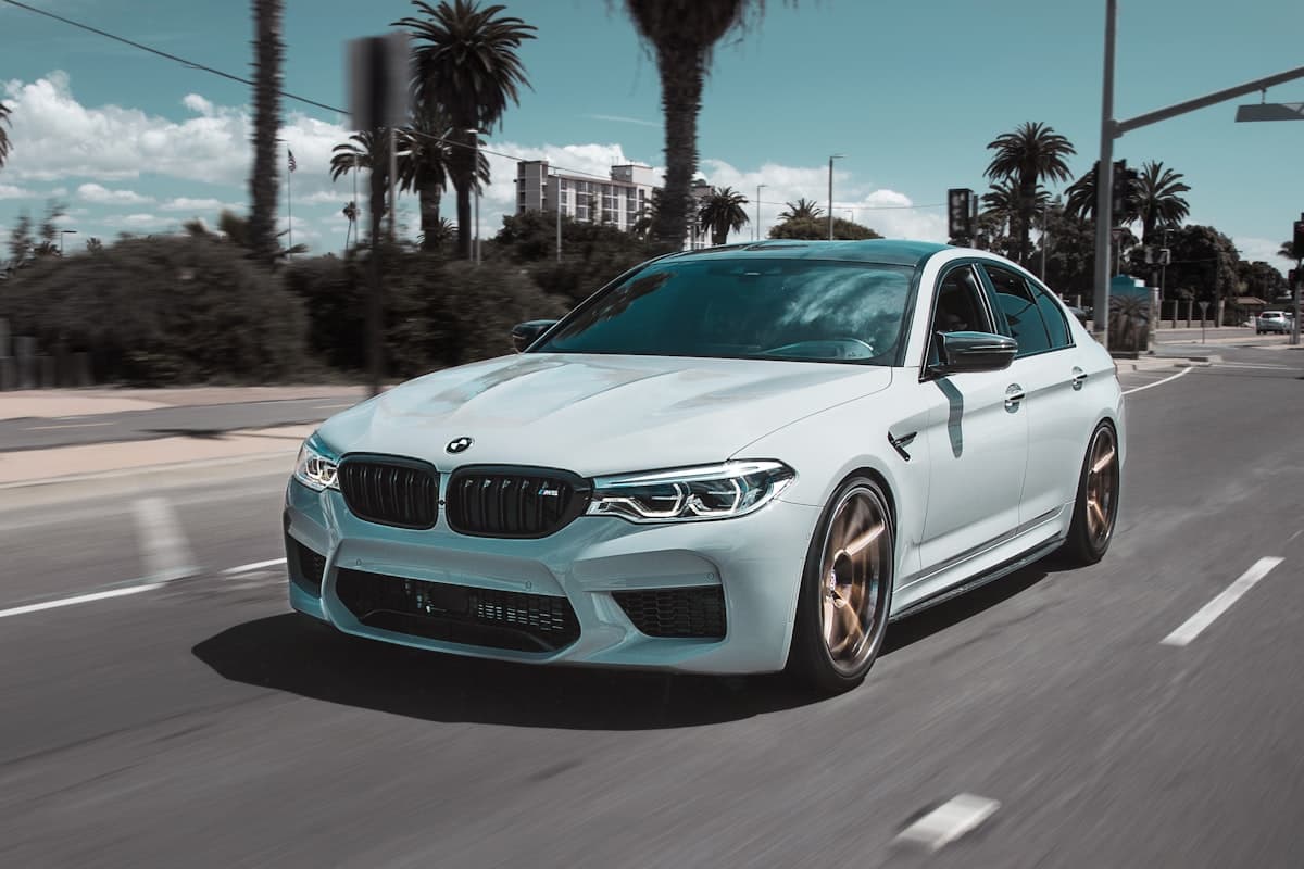 BMW M5 blanche sur route ensoleillée